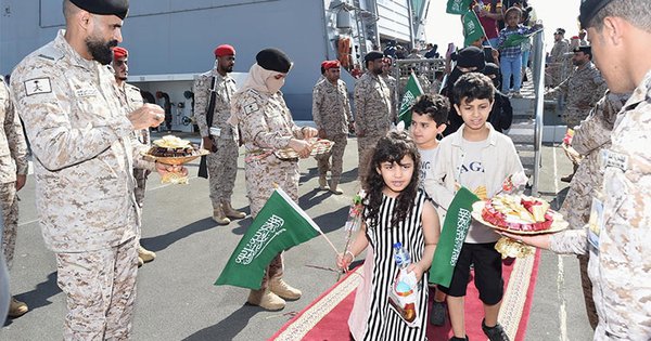 Lực lượng an ninh Ả Rập Saudi chào đón công dân Ả Rập Saudi và công dân các nước khác bằng sô cô la và hoa ở cảng Jeddah. Ảnh: SPA