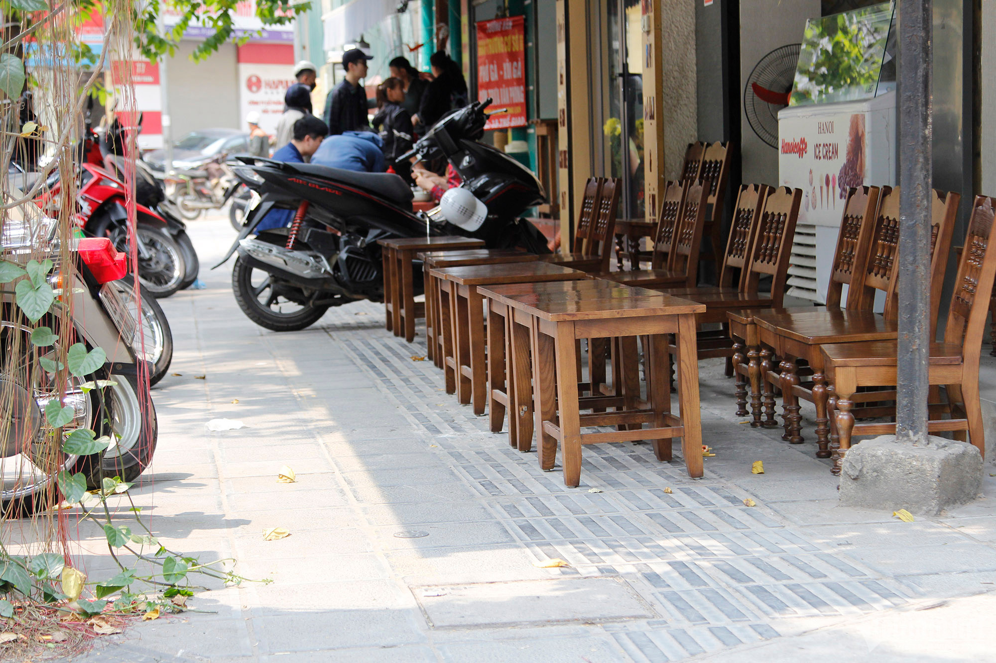 Trên phố Tô Hiến Thành, một quán cà phê xếp bàn ghế chiếm dụng vỉa hè, đường của người khiếm thị.