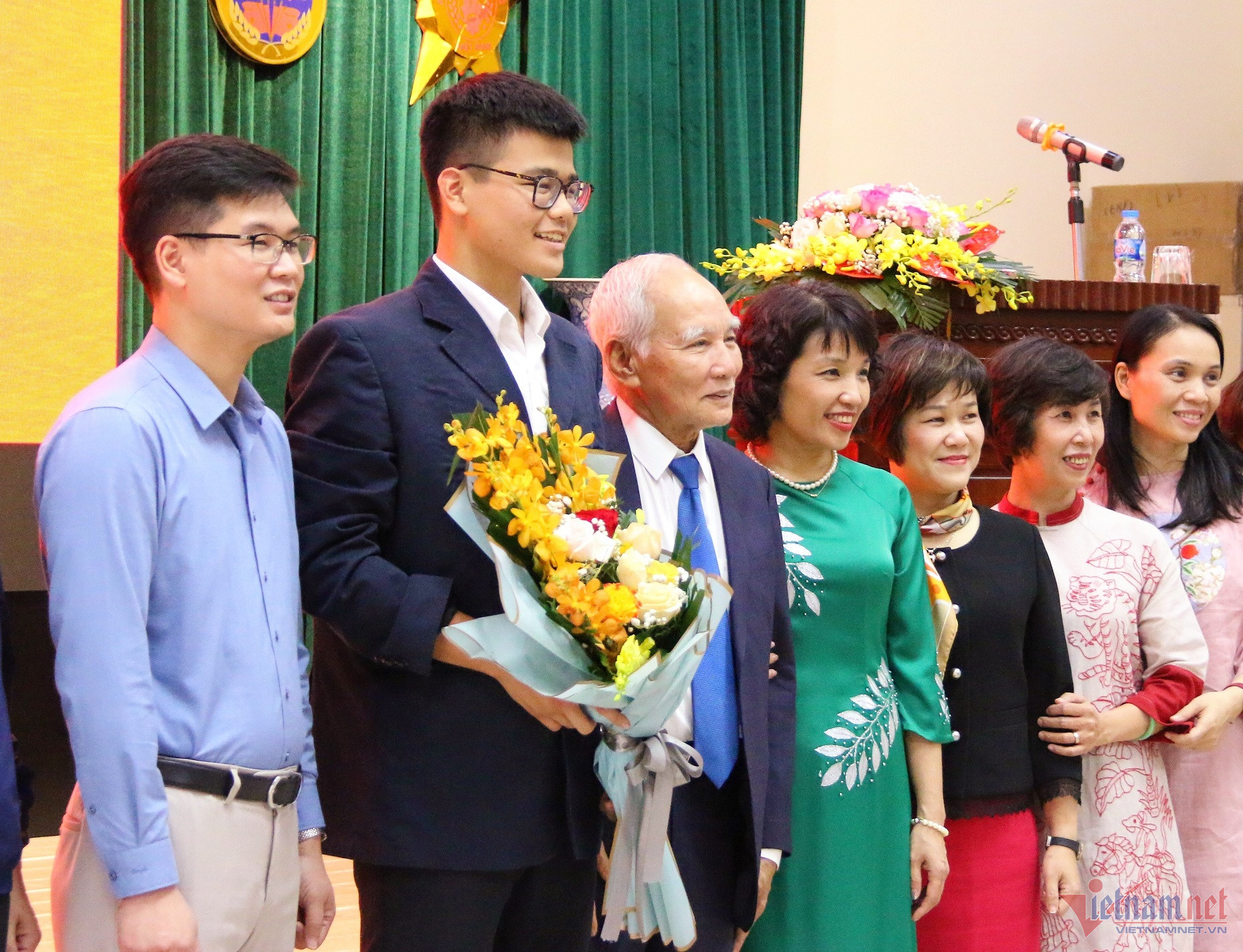 Hoàng Sơn cùng ông ngoại, mẹ (áo dài xanh) và các thầy cô giáo tại buổi lễ kết nạp Đảng. Ảnh: Thanh Hùng