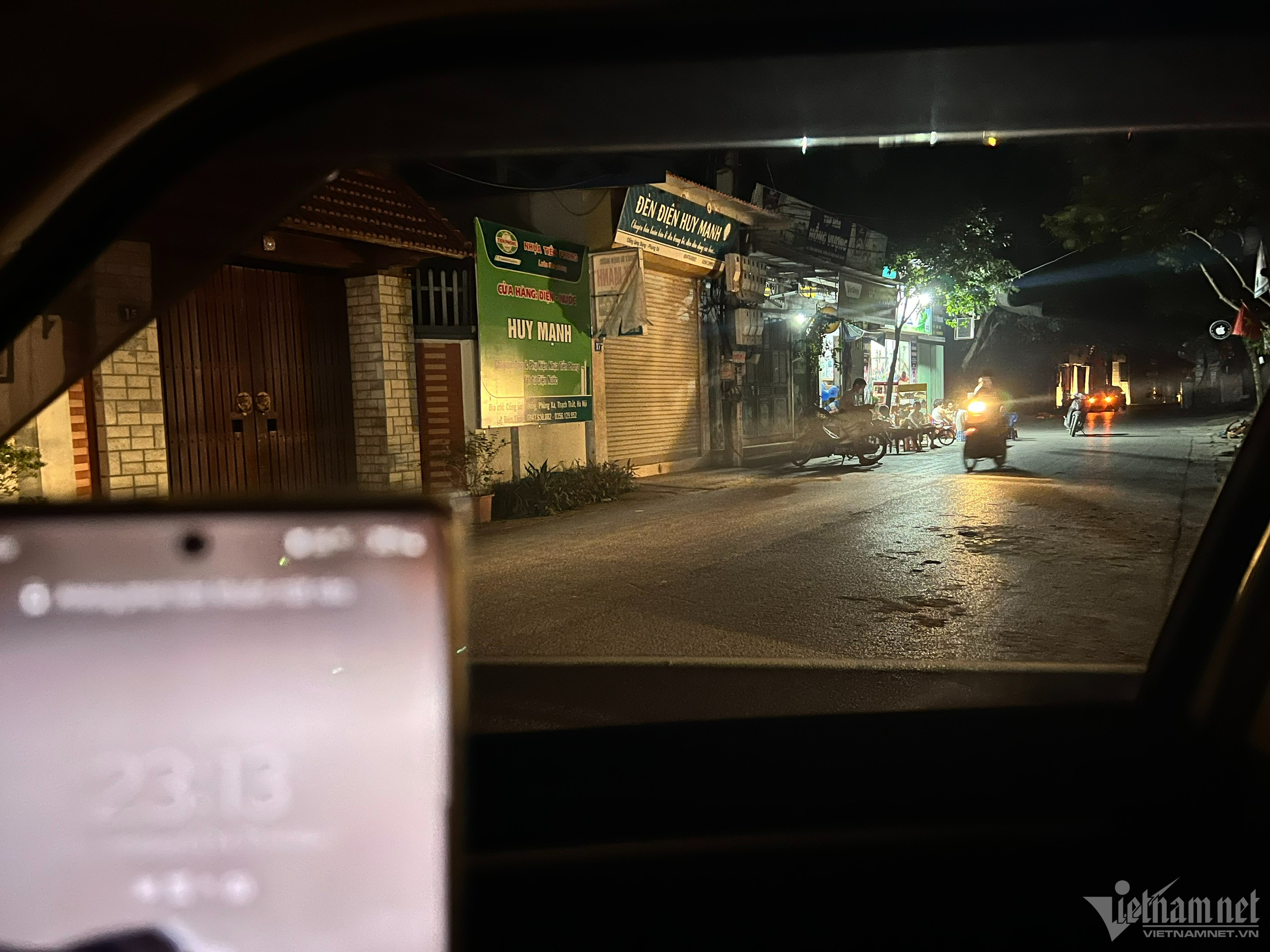 23h13, đường làng vẫn đông người qua lại.