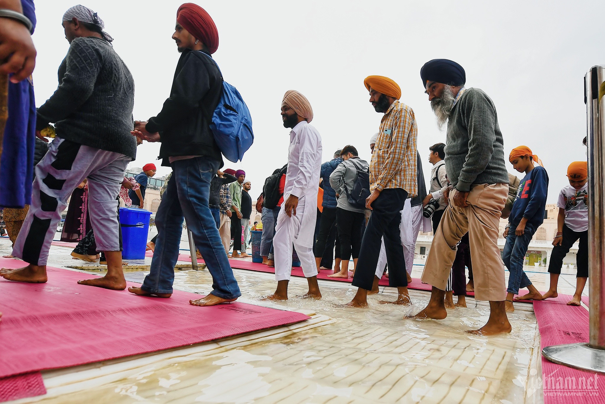 Trước khi qua cổng, du khách được hướng dẫn phải giẫm chân xuống nước rửa. 