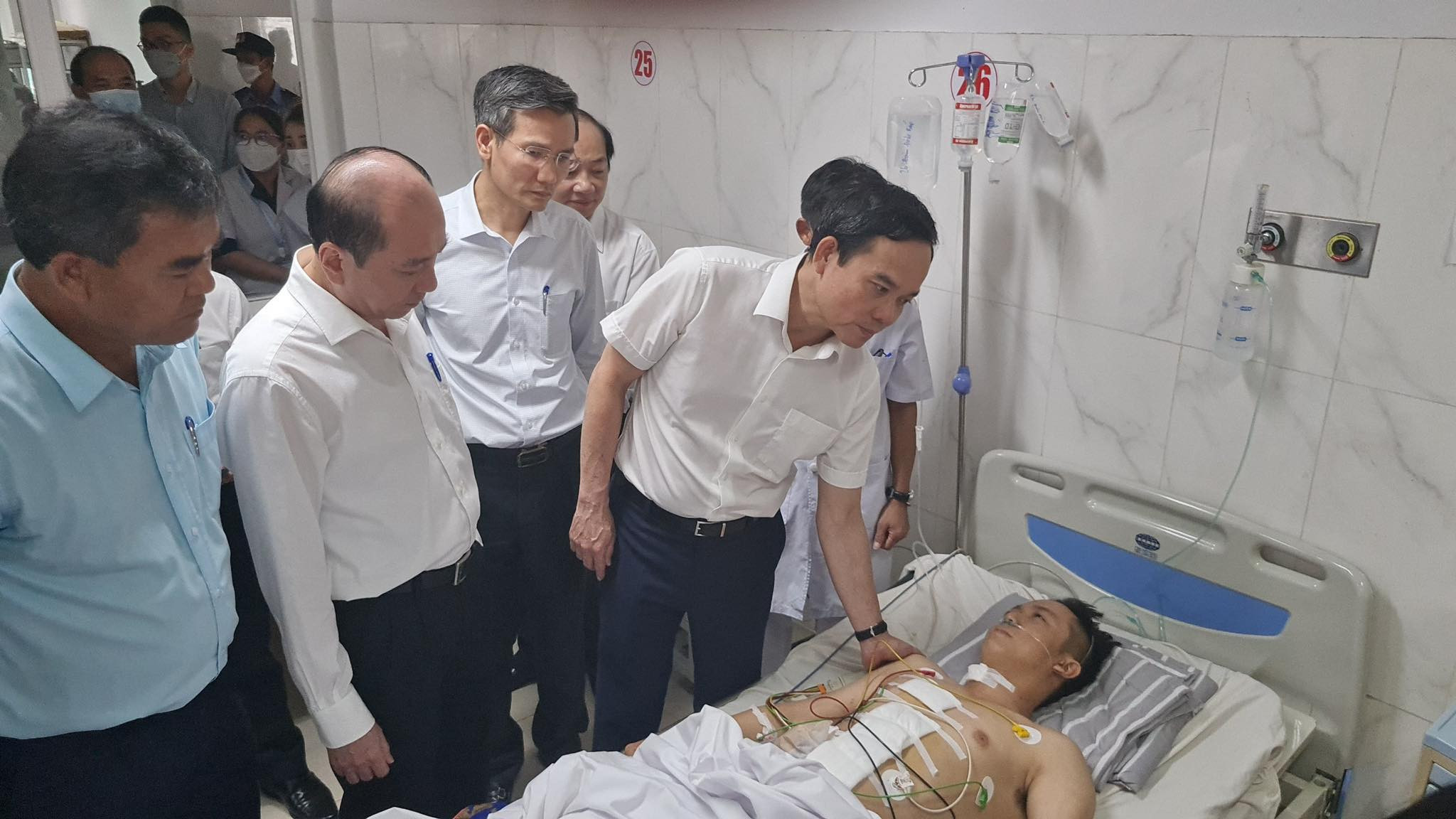 Phó Thủ tướng Trần Lưu Quang thăm hỏi Thượng úy Đàm Đình Bốp khi anh đang được điều trị tại Bệnh viện đa khoa vùng Tây Nguyên vào ngày 12/6. Ảnh: CTV