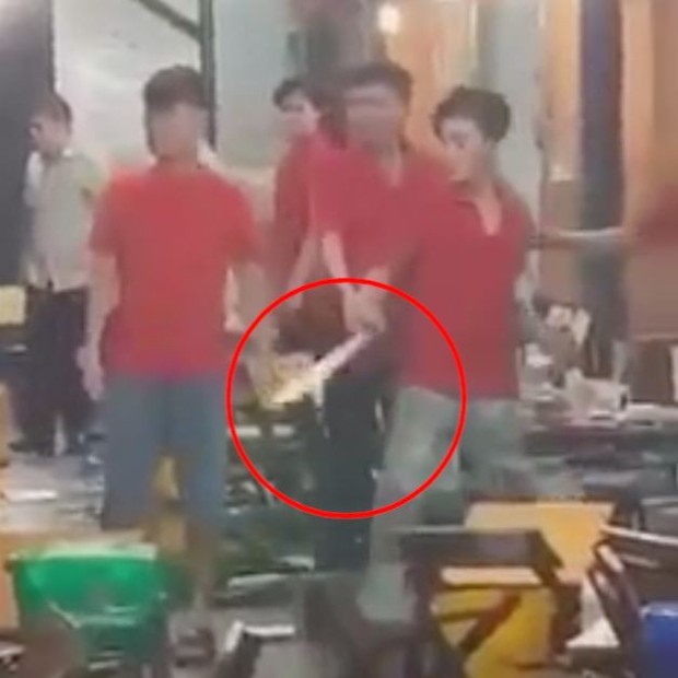 Nam nhân viên cầm mã tấu đe dọa khi thấy đồng nghiệp bị ném ly bia (Ảnh cắt từ clip)