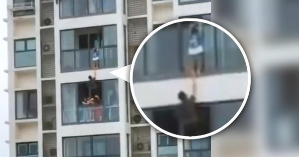 Khoảnh khắc thót tim khi anh Wang lao ra ngoài ban công và đỡ lấy cậu bé trong tư thế cực kỳ chơi vơi, với sự giúp sức của 3 người phụ nữ - Ảnh: SCMP