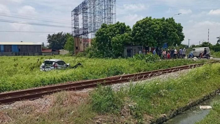 Chiếc ô tô bị hất văng xuống ruộng cạnh đường sắt.