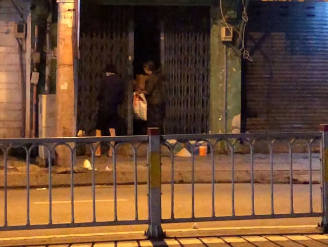 Người ăn xin cất quà từ thiện vừa xin được vào nhà và trở ra xin tiếp. Ảnh: LÊ VĨNH