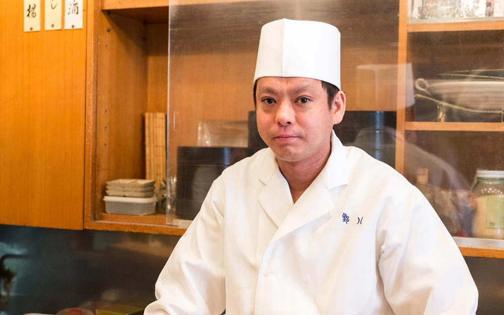 Mỗi miếng chỉ được làm bằng một hạt gạo và một lát topping nhỏ được bọc trong miếng nori mỏng nhất. Tất cả đều là tác phẩm của Hironori Ikeno, chủ nhà hàng Sushiya no Nohachi và đồng thời cũng là người đã nảy ra ý tưởng này vào năm 2002 khi một khách hàng hỏi anh rằng anh có thể làm món sushi nhỏ đến mức nào.