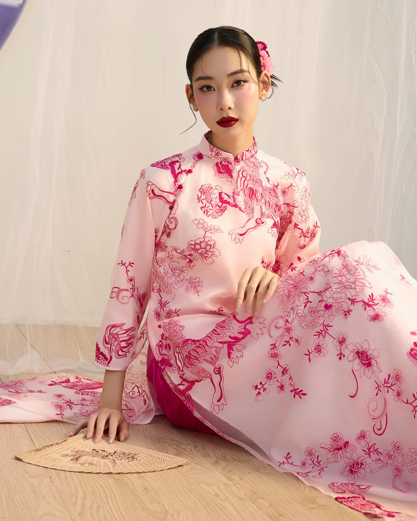 Thiết kế của HOIVU khác đôi chút, mẫu áo tay lửng nhẹ nhàng, điểm xuyết phần khuy bọc lụa hồng xuyệt tông. Thiết kế được đặt tên là 