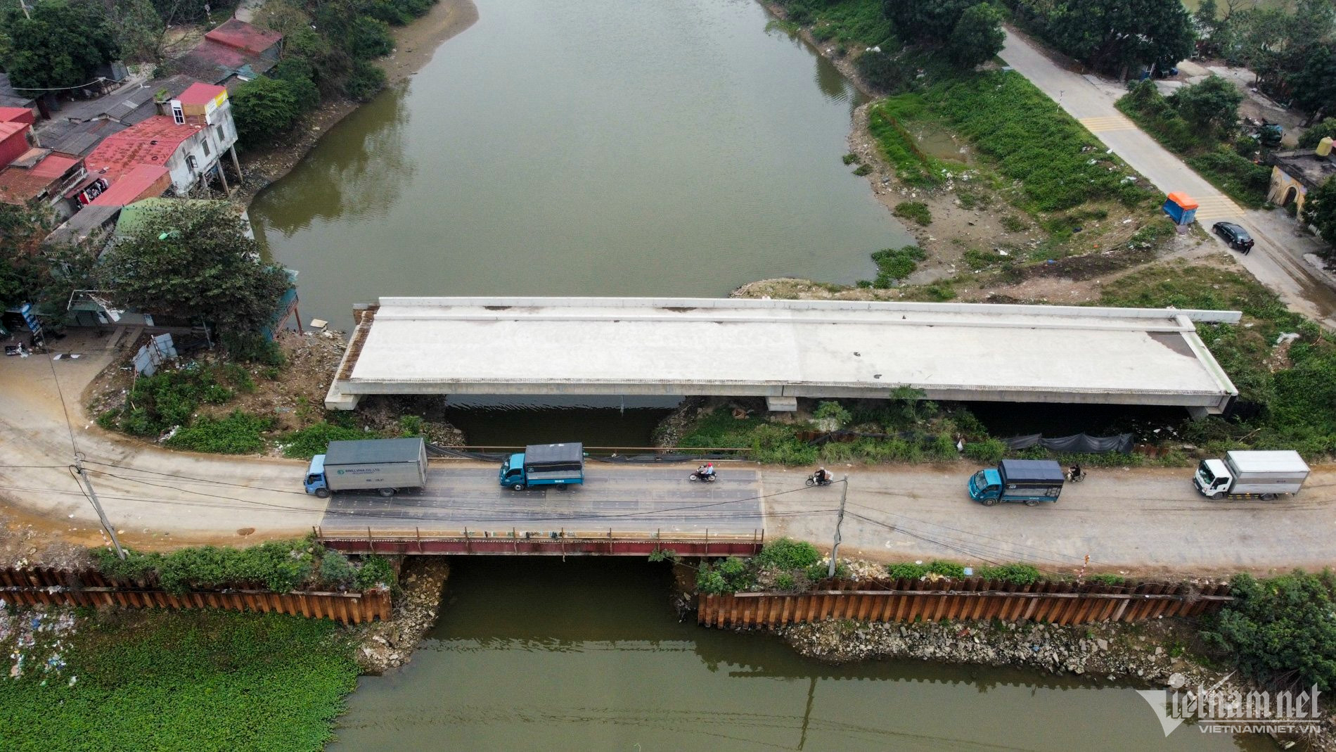 Trong khi chờ cầu mới hoàn thành, người dân vẫn phải đi qua cầu tạm xuống cấp.