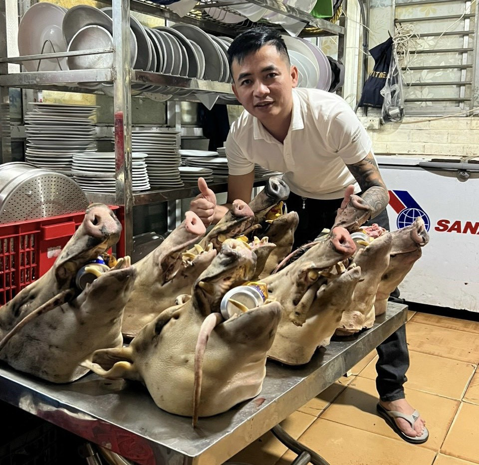 Anh Dũng (chủ nhà hàng) bên cạnh những thủ lợn rừng sắp giao cho khách. 
