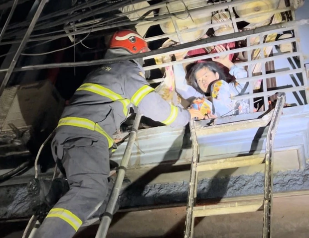 Lực lượng chức năng đưa người mắc kẹt ra ngoài từ tầng trên ngôi nhà xảy ra cháy