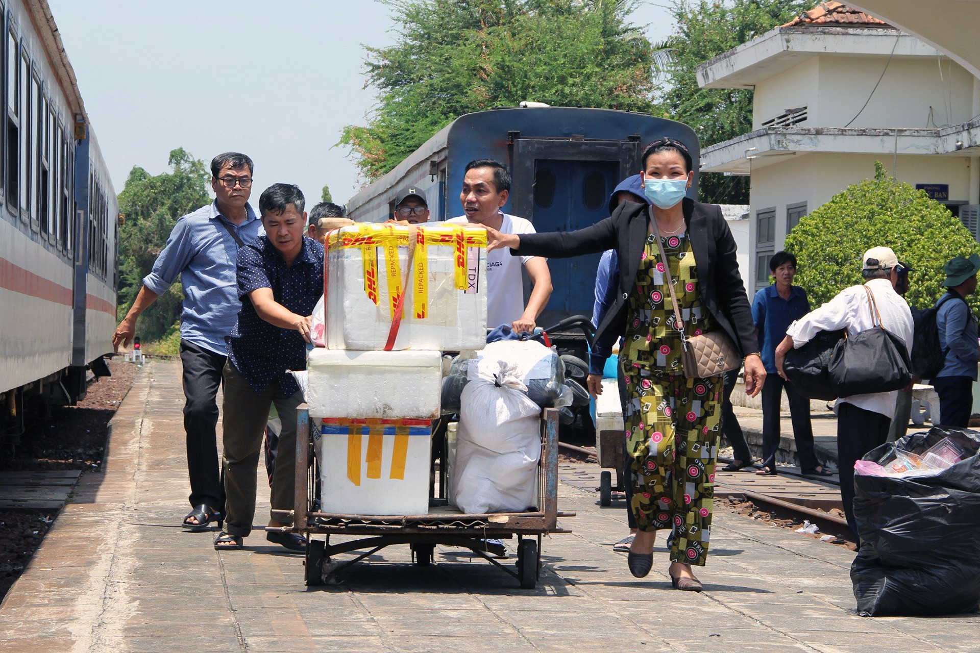 Hành khách được hỗ trợ lên ô tô trung chuyển qua điểm sạt lở. Ảnh: Phong Điền.