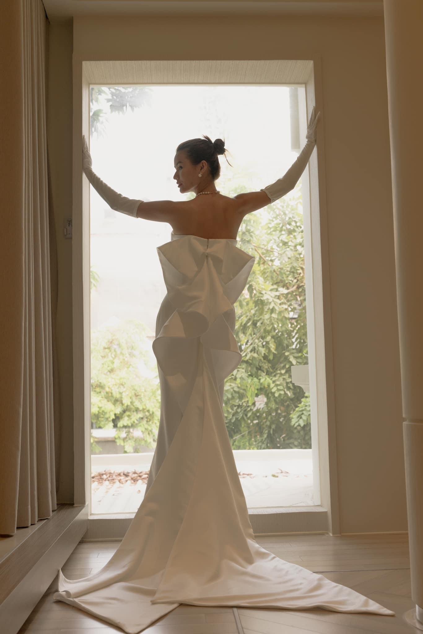 Cao Thiên Trang xinh đẹp tiếp đón quan khách đến dự tiệc trong chiếc váy cưới trắng tinh khôi. Thiết kế tối giản khâu đính kết cầu kỳ, tập trung tôn vinh vóc dáng của cô dâu với những đường cắt may công phu, kỹ lưỡng.