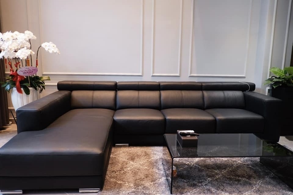 Phòng khách căn nhà có một chiếc sofa đen sang trọng và thu hút