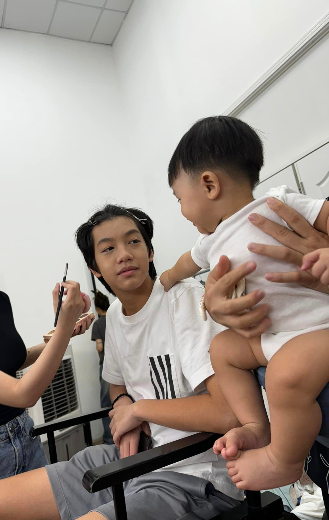 Dù đang bận trang điểm nhưng Subeo vẫn nhìn và chơi cùng em trai Sutin