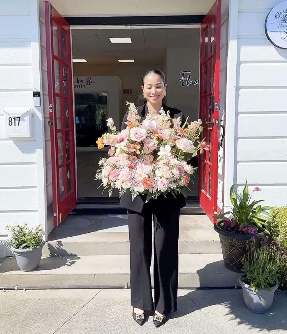 Phạm Hương đặt hoa trước bụng để che dáng 