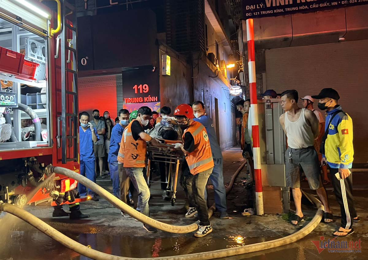 Lực lượng chức năng đưa nạn nhân trong vụ cháy nhà cho thuê ở Trung Kính ra ngoài. Ảnh: T. D.