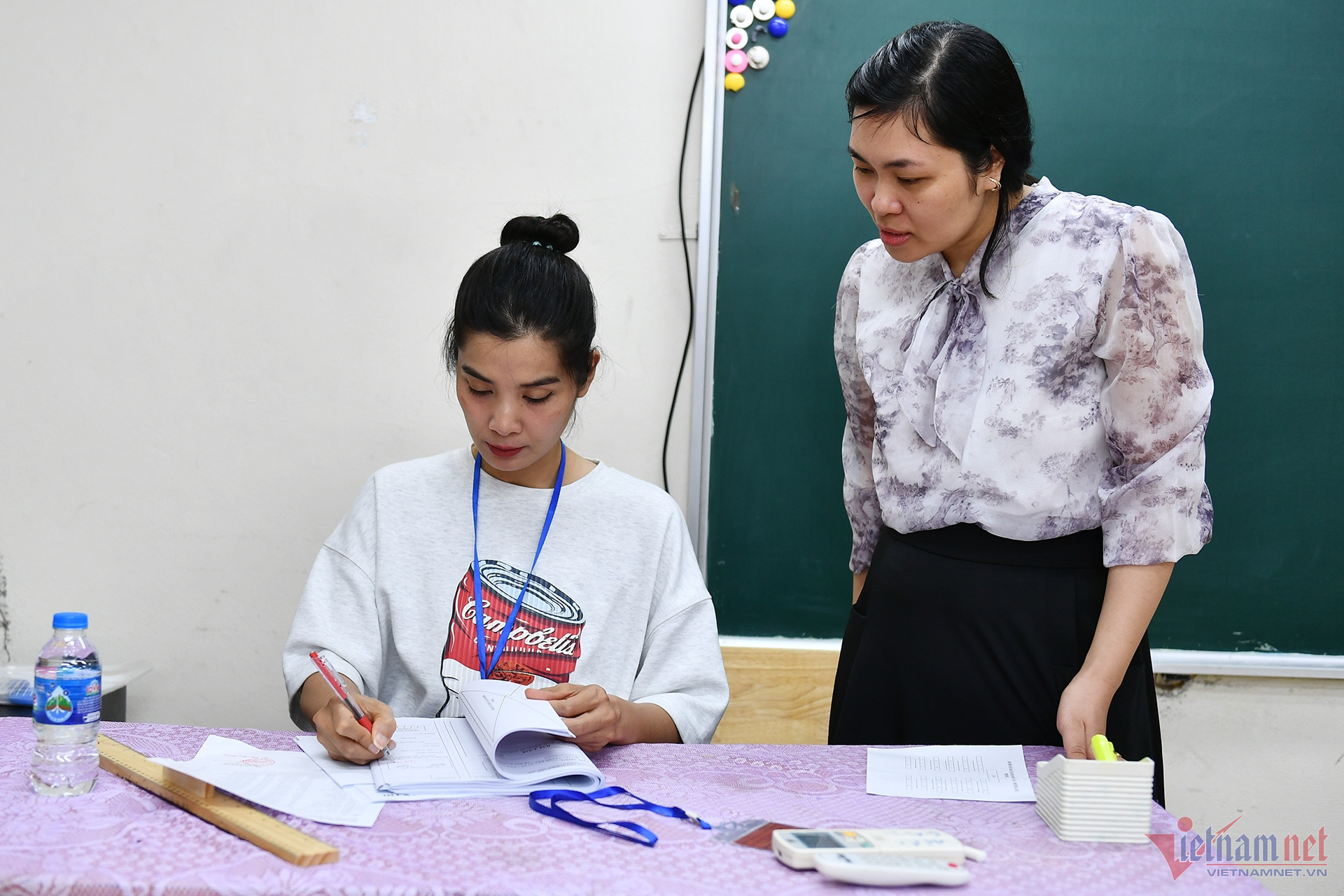 Giám thị kiểm tra cẩn thận hồ sơ trước giờ làm bài của thí sinh. Ảnh: Hoàng Hà