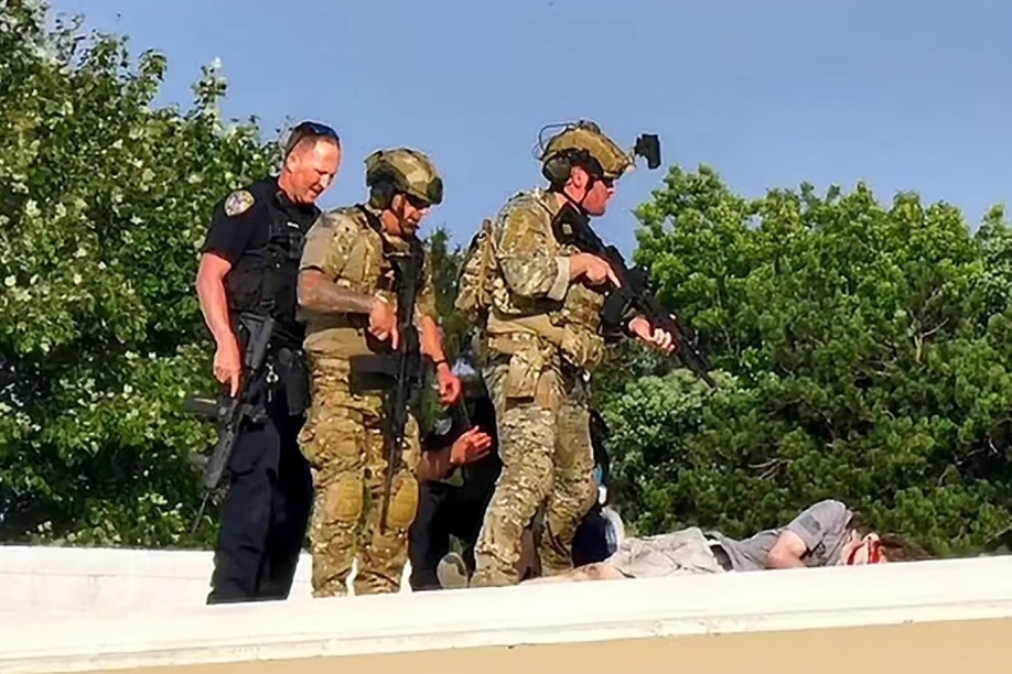 Các nhân viên an ninh Mỹ đứng cạnh thi thể của nghi phạm Crooks trên mái của một ngôi nhà gần sân khấu diễn thuyết của ông Trump. Ảnh: New York Post