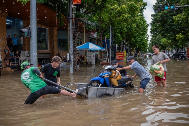 Xe máy được cho lên chiếc xe kéo để di chuyển về nhà cùng gạo và thức ăn