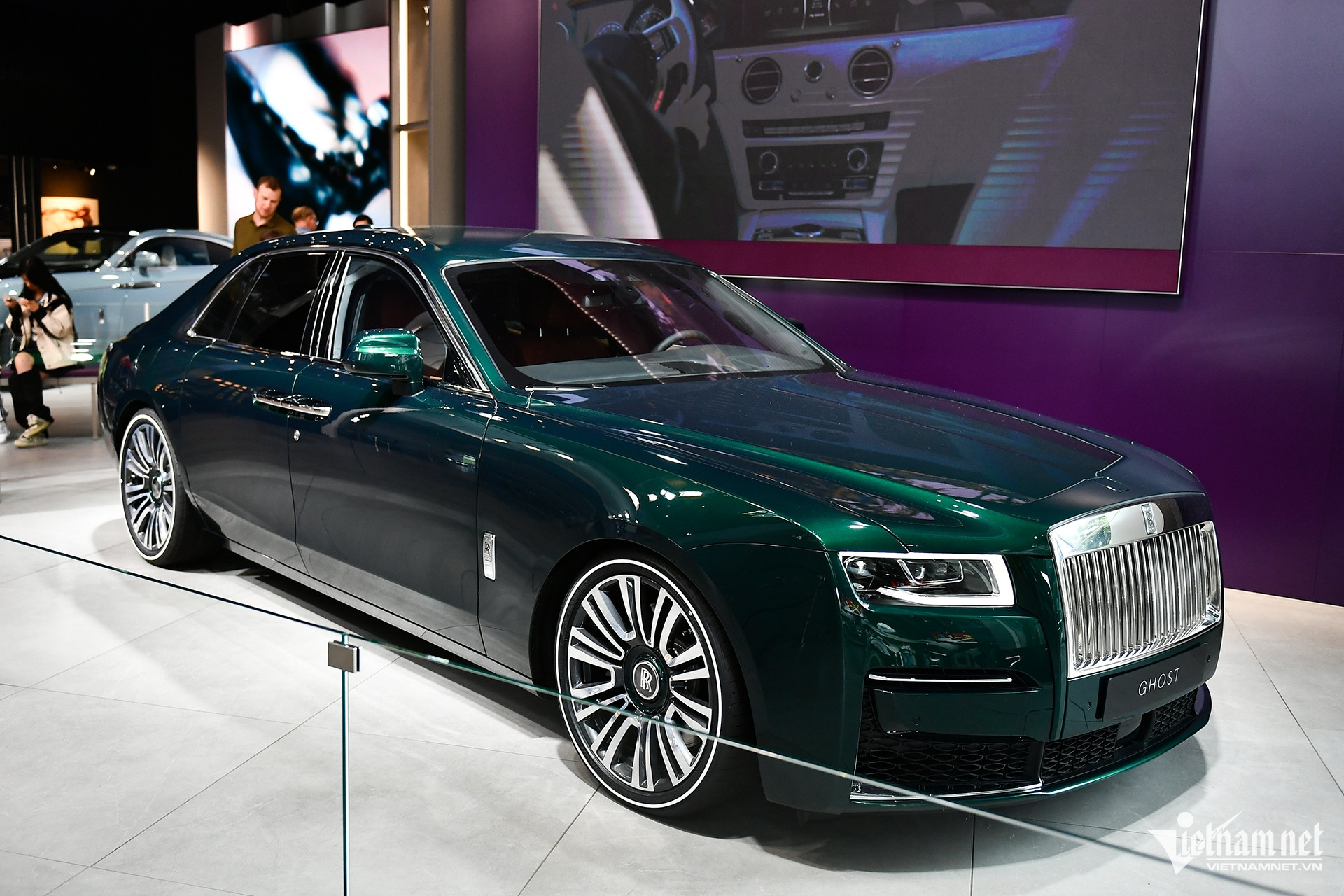 Ngay cửa vào khách sẽ gặp chiếc Rolls-Royce Ghost, biểu tượng xe sang hàng đầu toàn cầu. Chiếc xe này có độ dài ấn tượng, kích thước 5.399mm x 1.948mm x 1.550mm, được trang bị bộ vành 5 chấu độc đáo, kích thước lazang lên đến 21 inch. Ghost 2023 sở hữu động cơ Twin Turbo Premium Unleaded V-12, hộp số tự động 8 cấp, 563 mã lực, 780 Nm, thời gian tăng tốc từ 0 - 100km/h là 4,9s, tốc độ đạt tối đa 250km/h, mức tiêu thụ nhiên liệu 16,8 lít/100km. Nội thất của xe được bọc hoàn toàn bằng chất liệu gỗ quý hiếm và da cao cấp, đặc biệt là màn hình sao với hơn 850 điểm sáng LED, tạo nên không gian nổi bật.