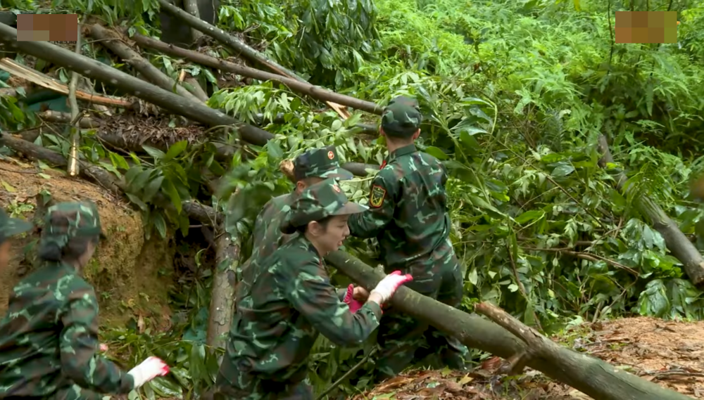 Các cô gái nỗ lực kéo, gạt bỏ các cành cây bên trên nắp hầm.