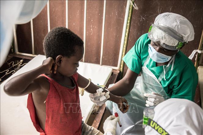 Nhân viên y tế lấy mẫu máu xét nghiệm cho em bé tiếp xúc với bệnh nhân mắc đậu mùa khỉ tại Zomea Kaka, CH Trung Phi. Ảnh tư liệu: AFP/TTXVN