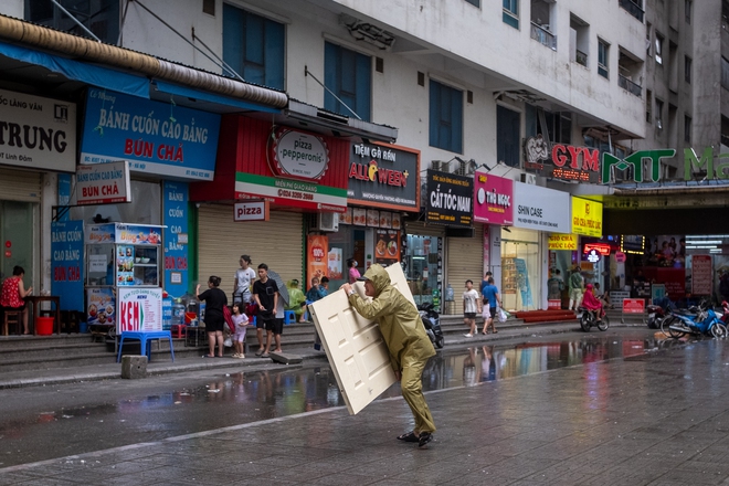 Tuy nhiên, một số người vẫn phải tranh thủ đi mua thực phẩm. Tại khu vực chợ dân sinh khu chung tư HH Linh Đàm, gió lớn khiến nhiều người di chuyển khó khăn