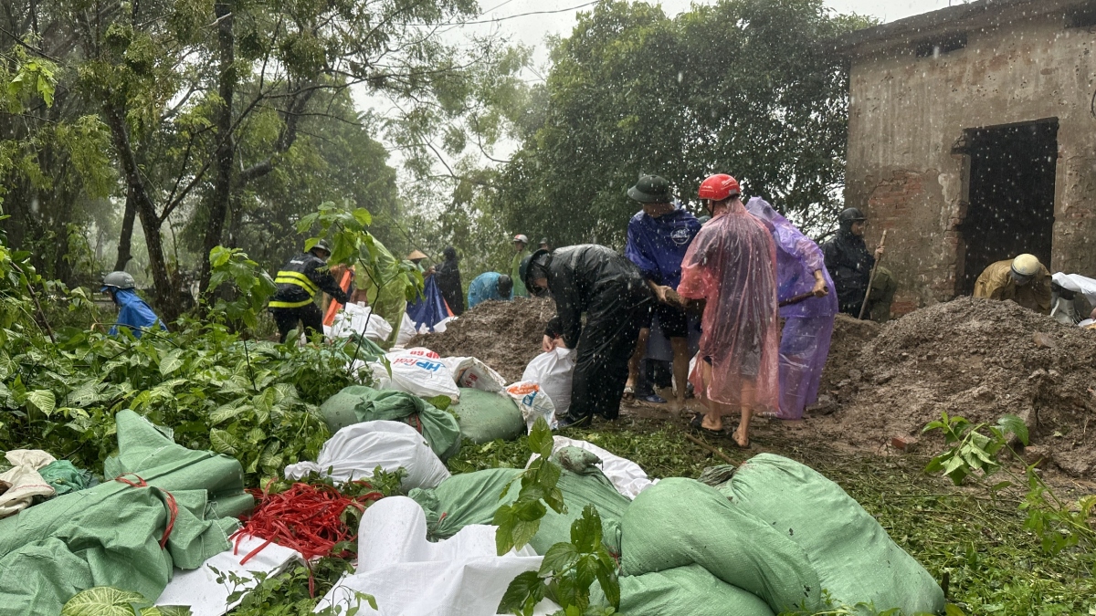 Hàng trăm bao tải cát chuẩn bị được chuyển xuống chặn cửa cống.