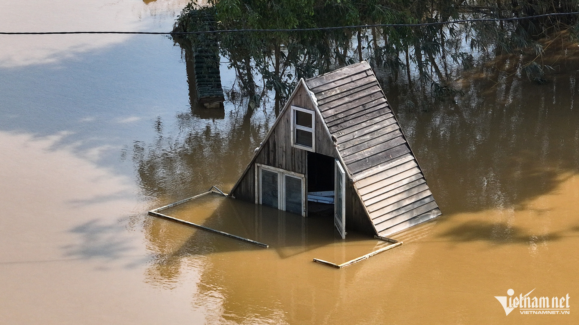 Một ngôi nhà gỗ kiểu châu Âu được dựng lên chủ yếu để phục vụ khách chụp ảnh đang bị ngập sâu hơn 1m, sáng 13/9. 