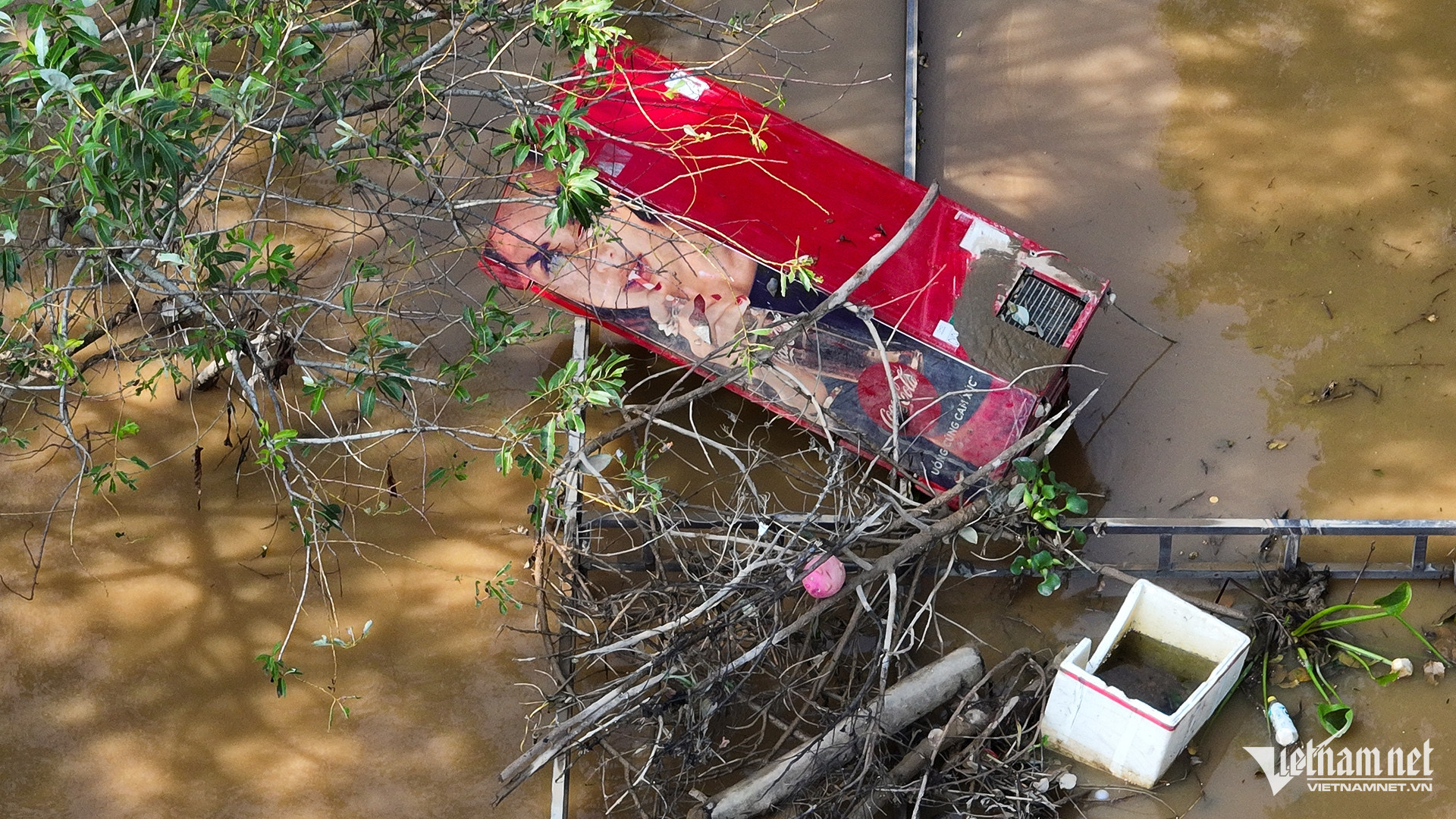 Tủ mát để nước ngọt bán hàng bị đánh đổ giữa sân mênh mông nước.