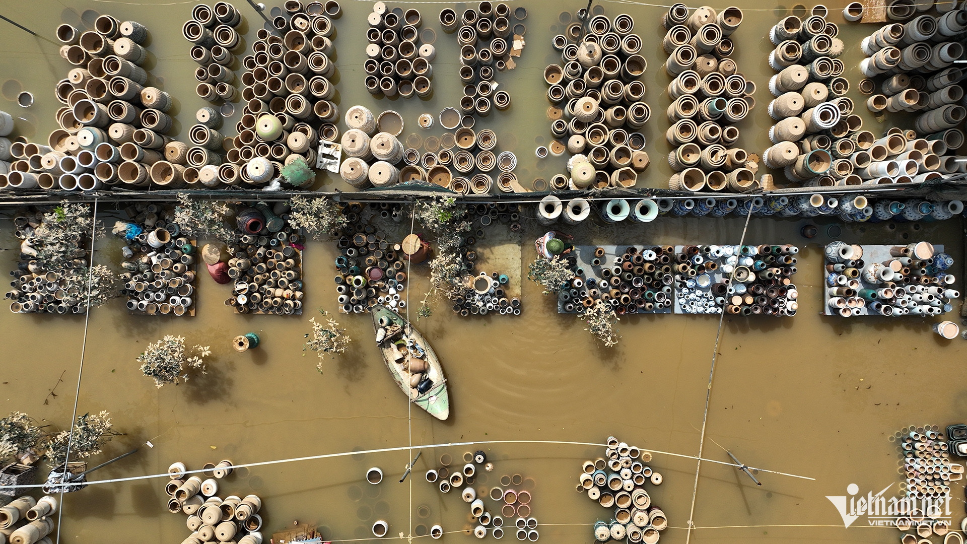 Một hộ kinh doanh chậu gốm sứ giữa cánh đồng Nhật Tân cũng bị thiệt hại khi rất nhiều bình, lọ do bị sóng đánh vỡ chìm dưới nước.