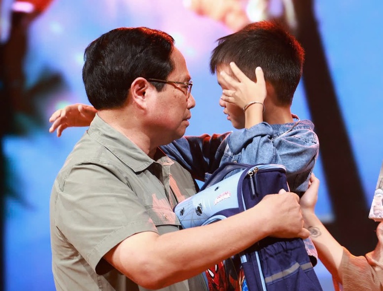 Thủ tướng Chính phủ Phạm Minh Chính động viên cháu Nguyễn Quốc Bảo. Ảnh: VGP