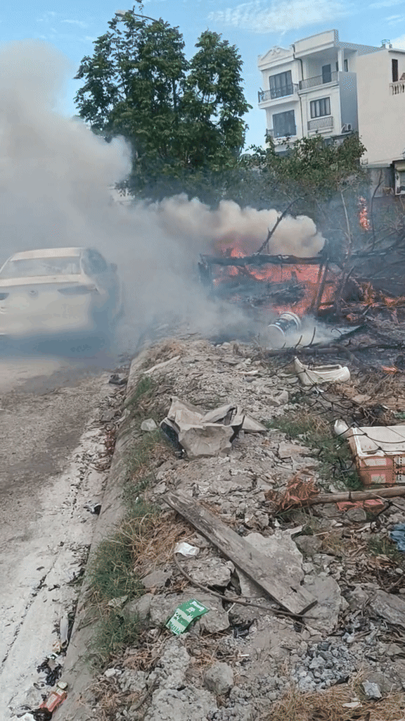 Đống rác và củi khô cháy bùng bùng, lan sang chiếc xe ô tô đỗ bên đường. 