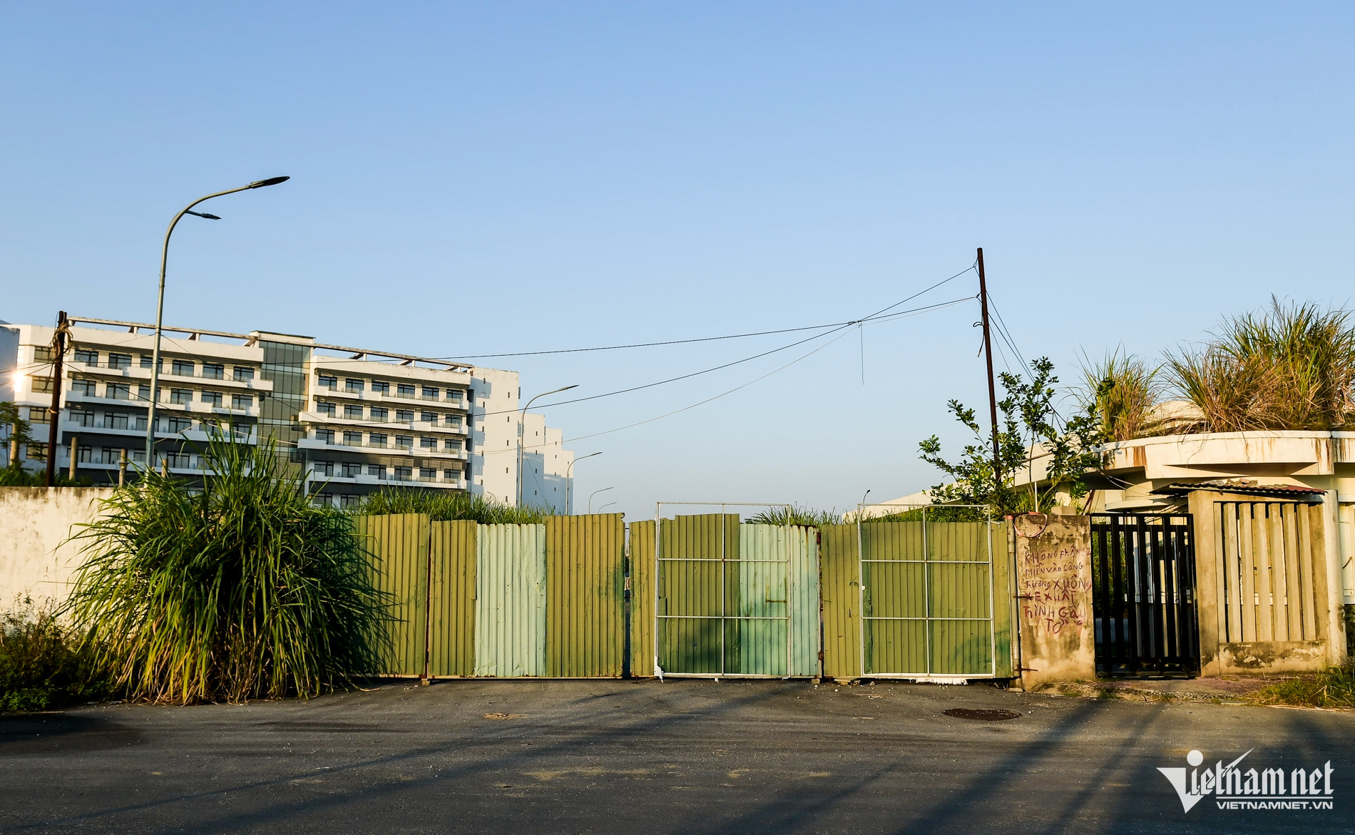 Cánh cổng phụ chưa lắp đặt, các tấm tôn được dựng làm cửa tạm.