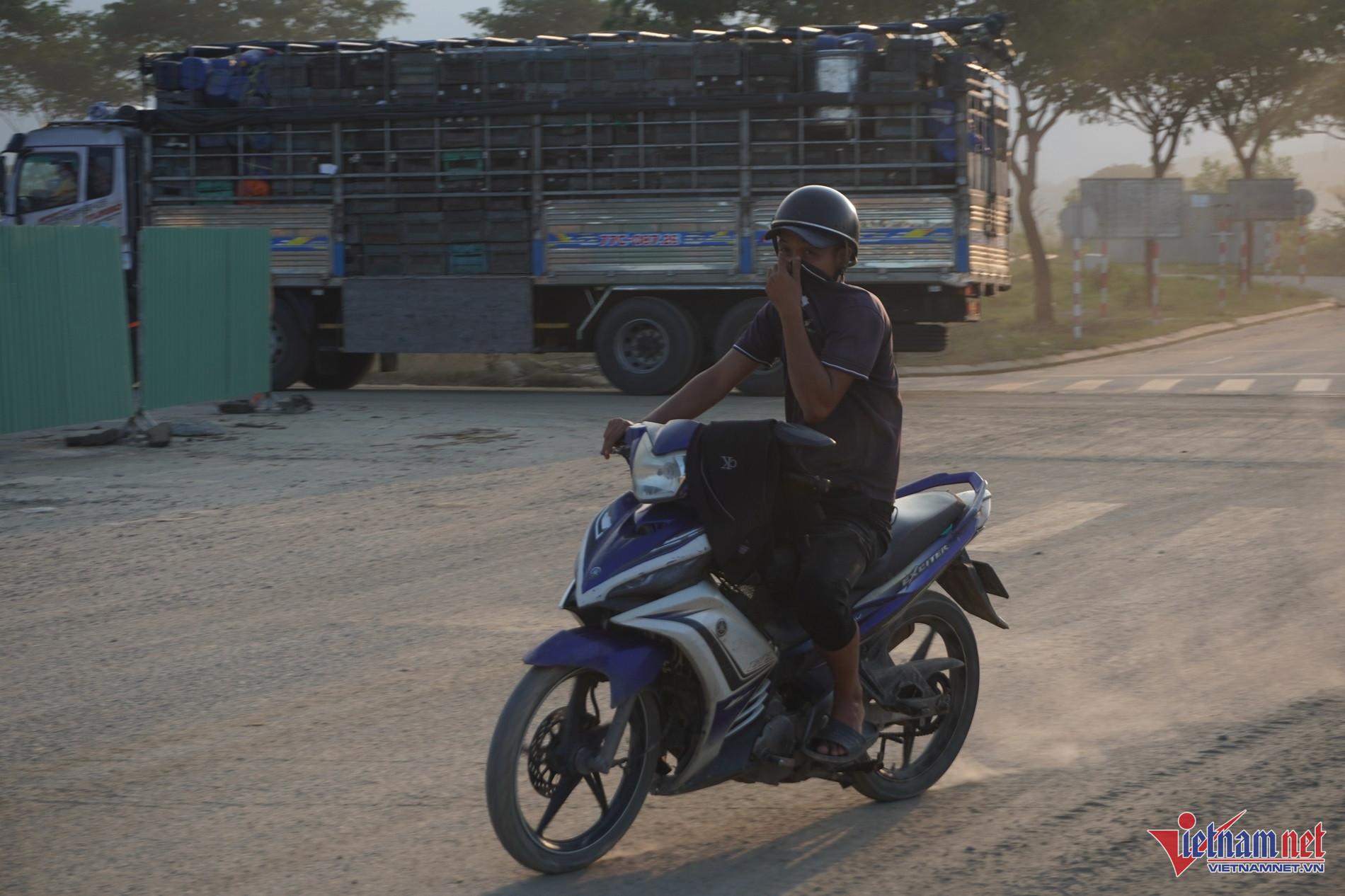 Người tham gia giao thông di chuyển qua khu vực mù mịt bụi.