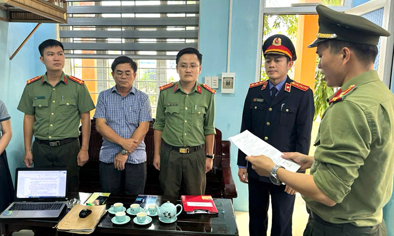 Cơ quan công an tống đạt quyết định khởi tố bị can và bắt tạm giam đối với Nguyễn Viết Sơn (Trưởng BQL các công trình công cộng huyện Lệ Thủy). Ảnh: Công an Quảng Bình