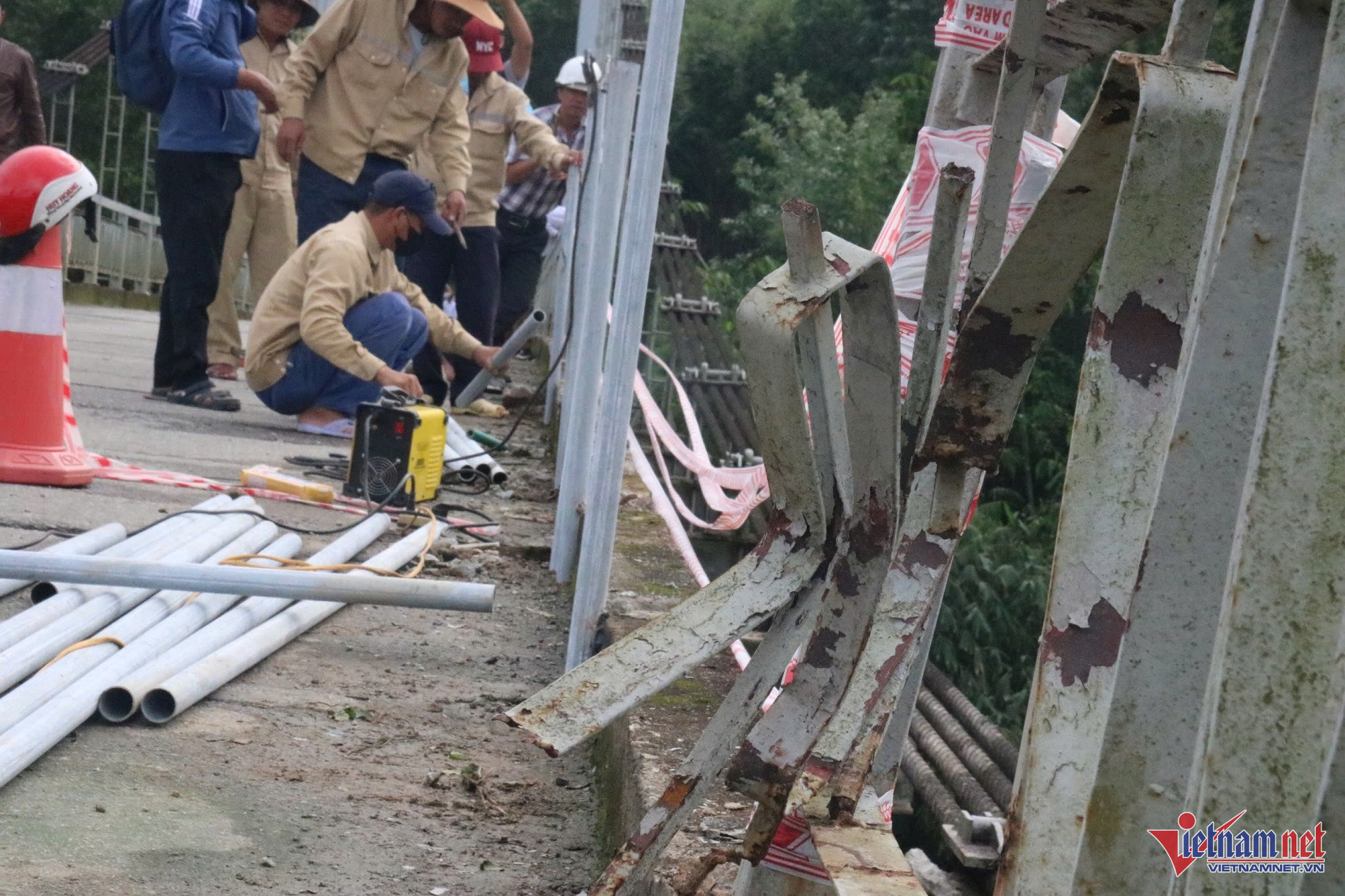 Khoảng 10m lan can cầu bị xe chở rác ủi bay trước khi lao xuống sông. Ảnh: QT