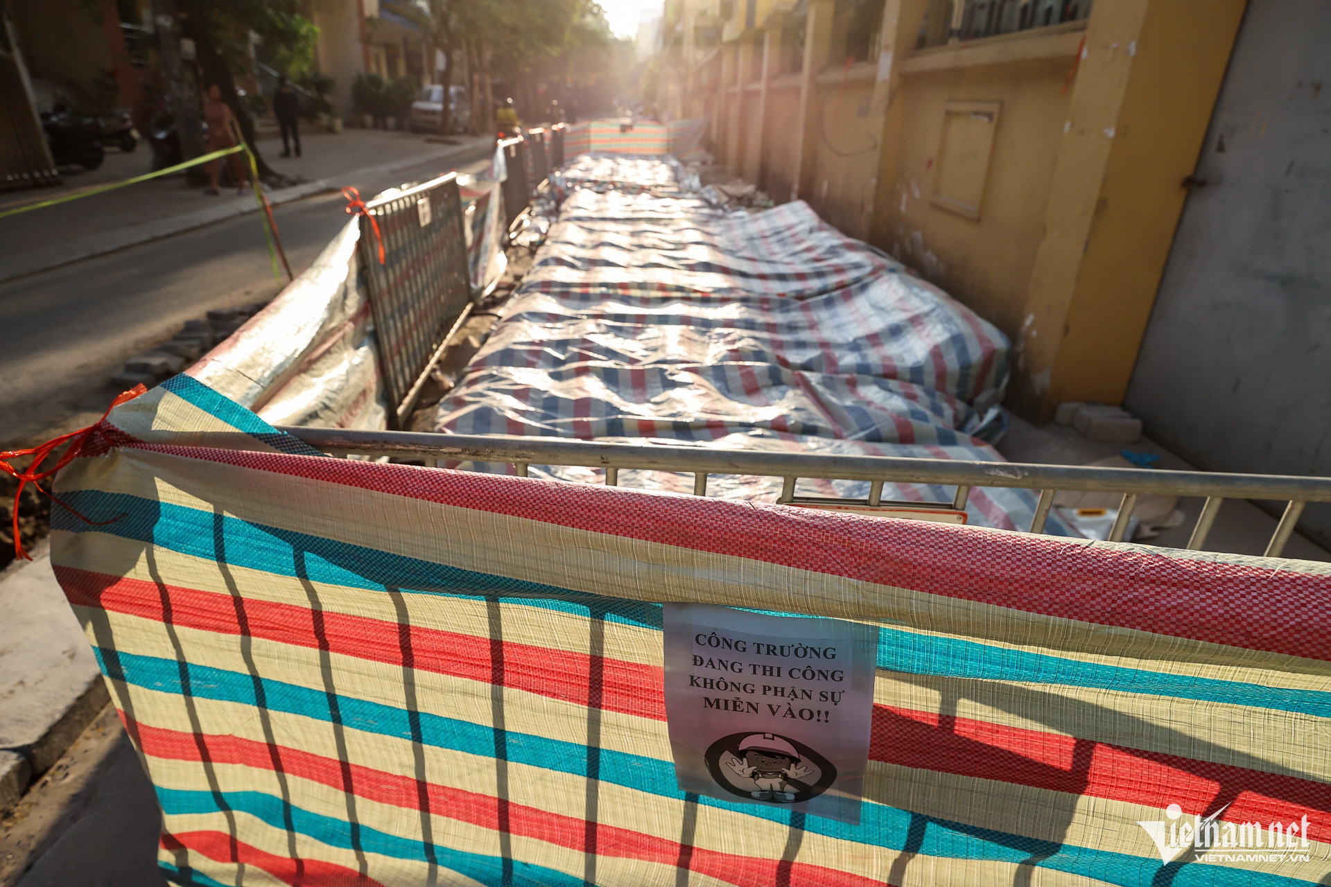 Những bộ hài cốt được tập kết, phủ bạt bên đường để chuẩn bị di chuyển tới nơi khác.