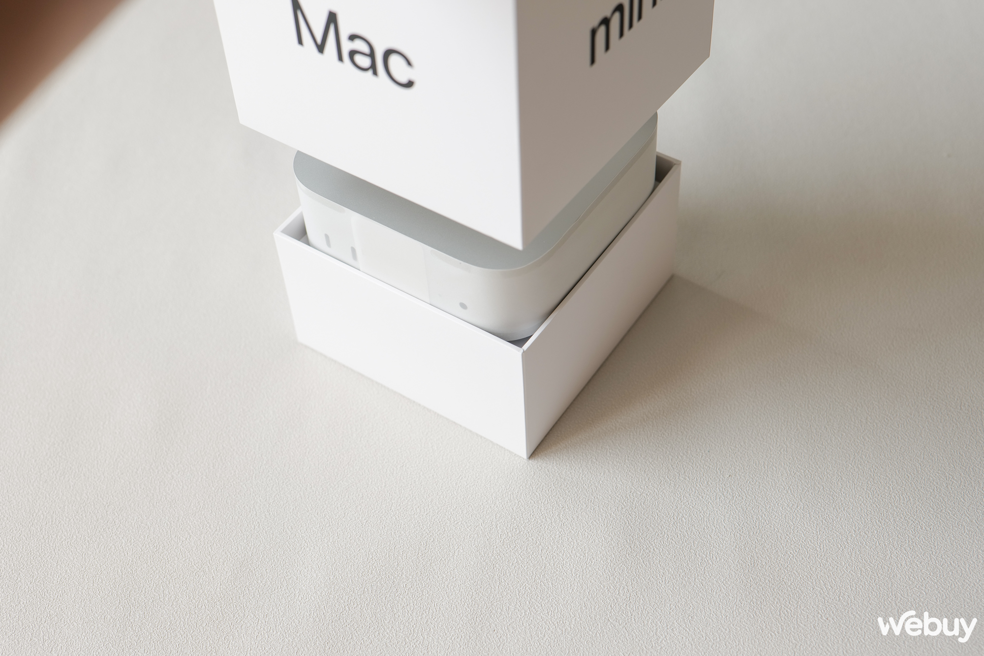 Nhấc nắp hộp lên, chúng ta thấy chiếc máy nhỏ nhắn nằm ngay phía dưới và được đặt trên một chân đáy. Đây là cách bố trí khá tinh ý của Apple, vì máy vừa khít với phần vỏ hộp bên trong nên nếu không làm như vậy thì có lẽ phải úp ngược hộp xuống để Mac mini rơi ra.