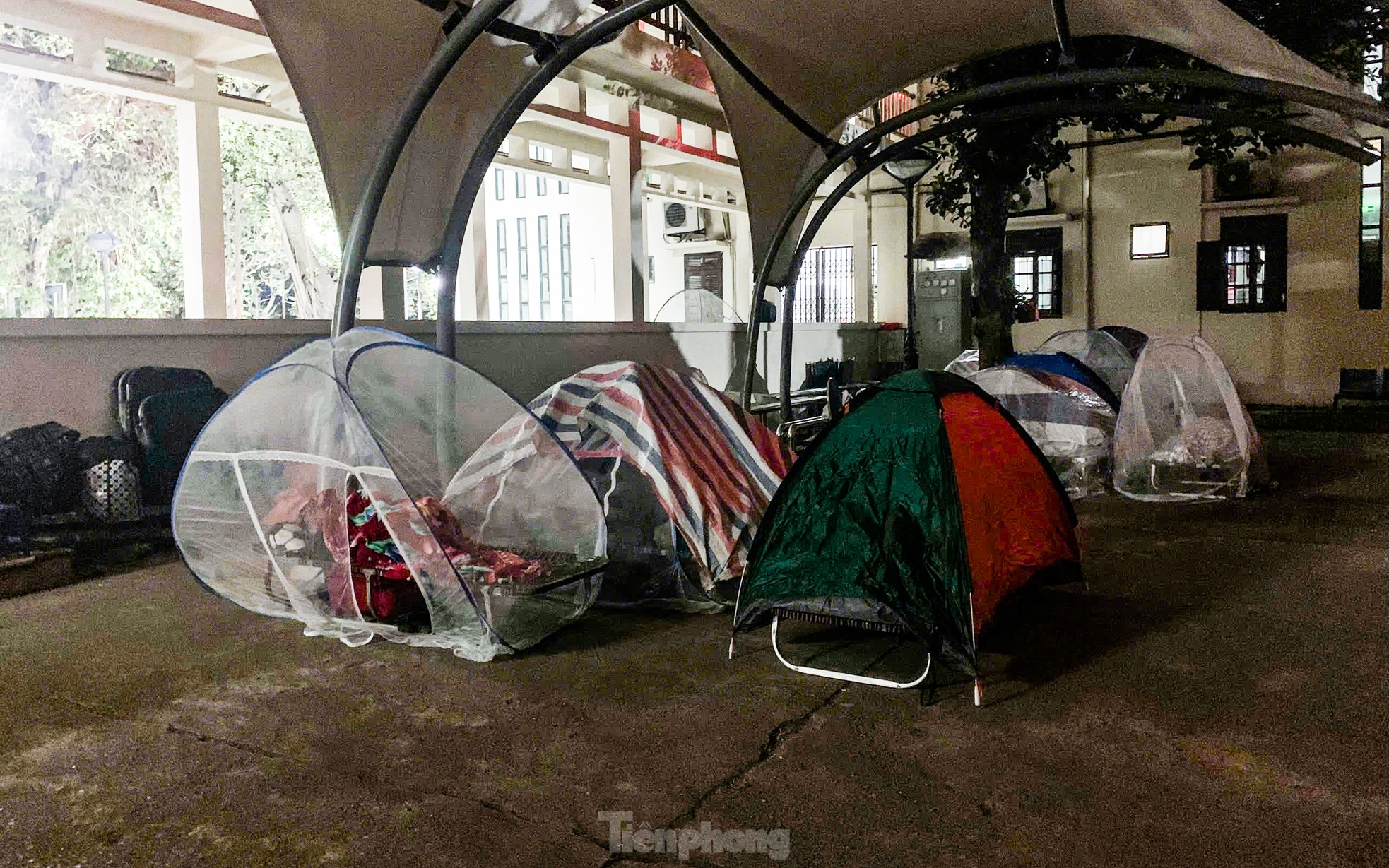 Khu vực sân và hành lang của tòa nhà 07 Khoa Thần kinh, Bệnh viện Bạch Mai, có rất nhiều lều trại của người nhà bệnh. Họ cố gắng tạo ra một không gian nghỉ ngơi tạm bợ để thuận tiện chăm sóc và theo dõi tình hình sức khỏe của người nhà.