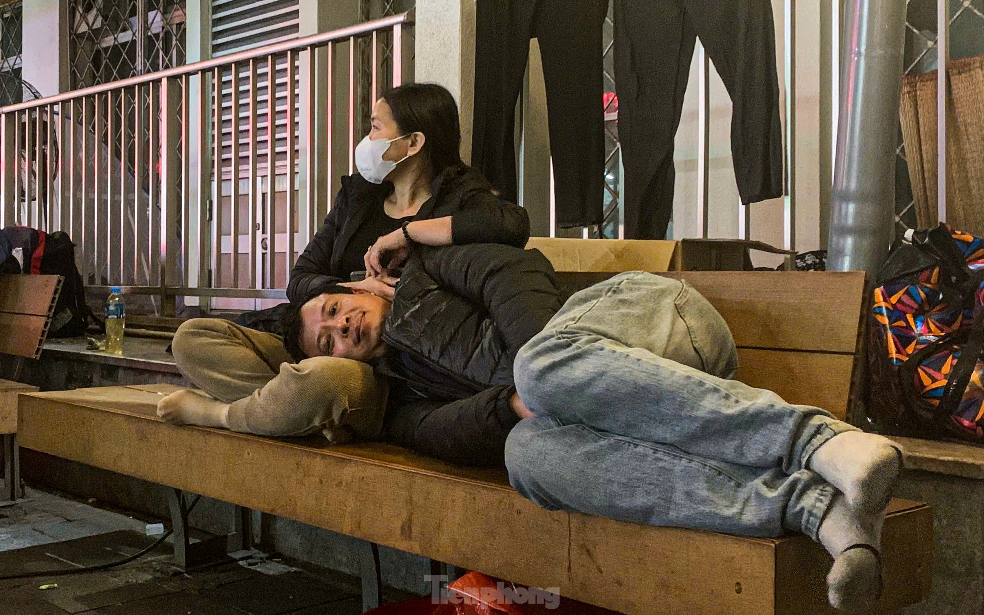 Người đàn ông nằm co ro trên chân vợ phía bên ngoài đối diện Trung tâm cấp cứu A9 Bệnh viện Bạch Mai. 