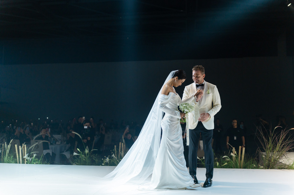 Sau khi đón khách, cô dâu Minh Tú và chú rể Christopher xuất hiện trong lễ phục trắng như công chúa và hoàng tử. Minh Tú xúc động rơi nước mắt khi bước vào lễ đường. Cặp đôi thực hiện nghi lễ “rót gạo”, tượng trưng cho sự hòa hợp và gắn kết bền chặt.