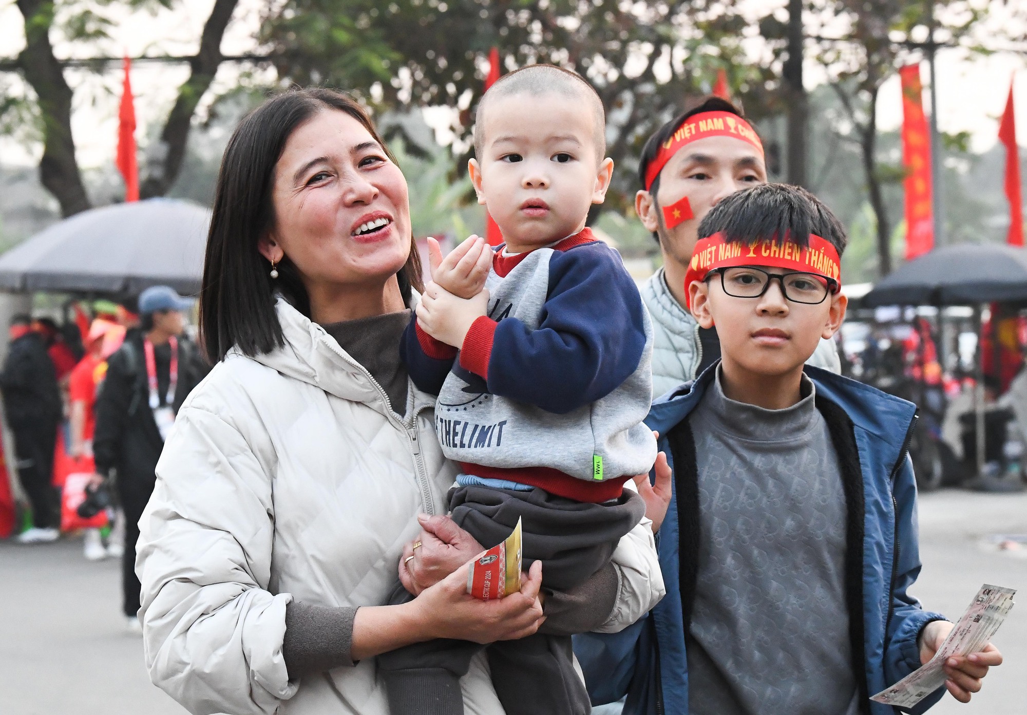 Một CĐV trung niên tươi tắn bế theo cháu đến sân cổ vũ