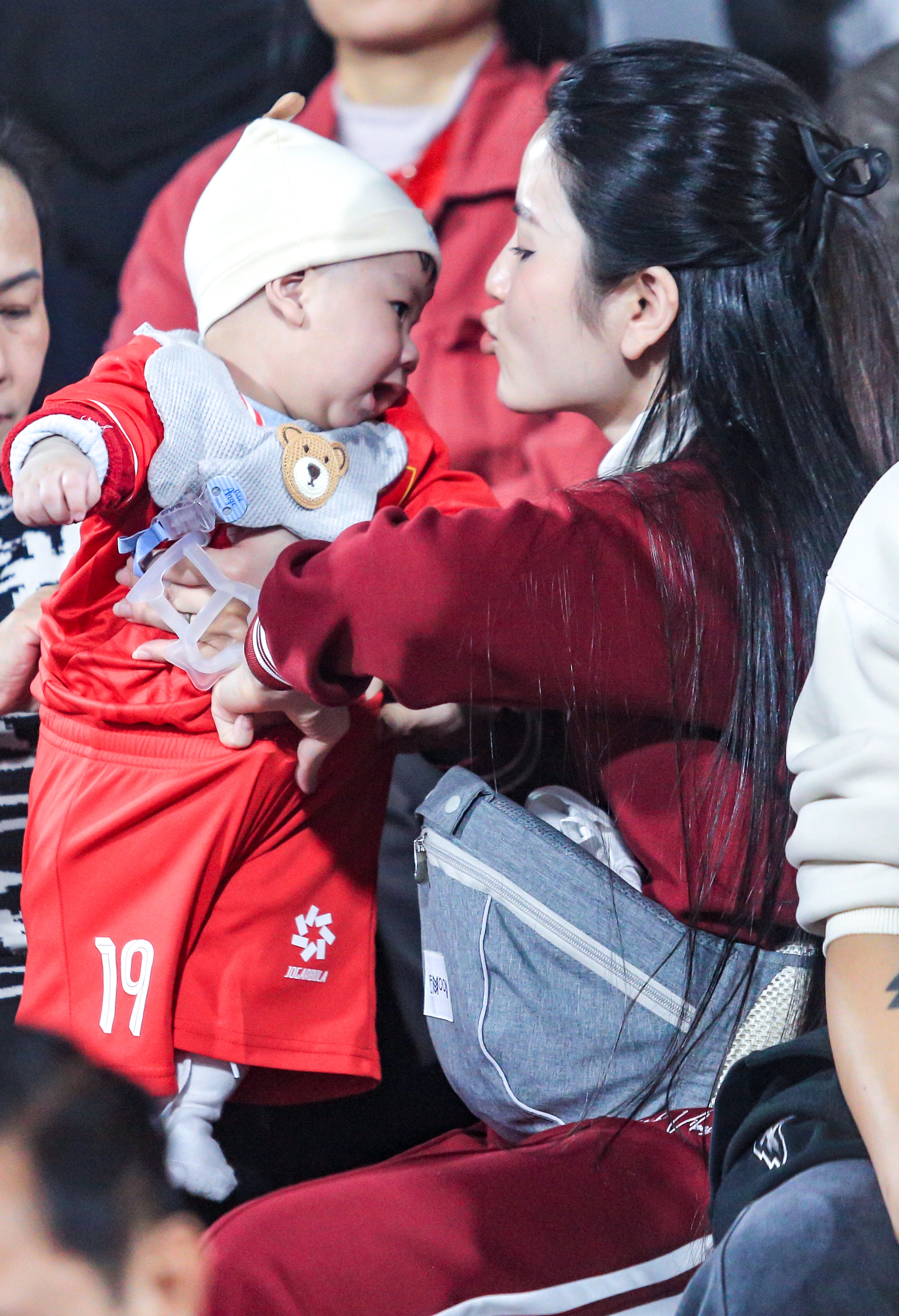 Cô nàng chăm sóc con trai trong lúc chờ trận đấu bắt đầu