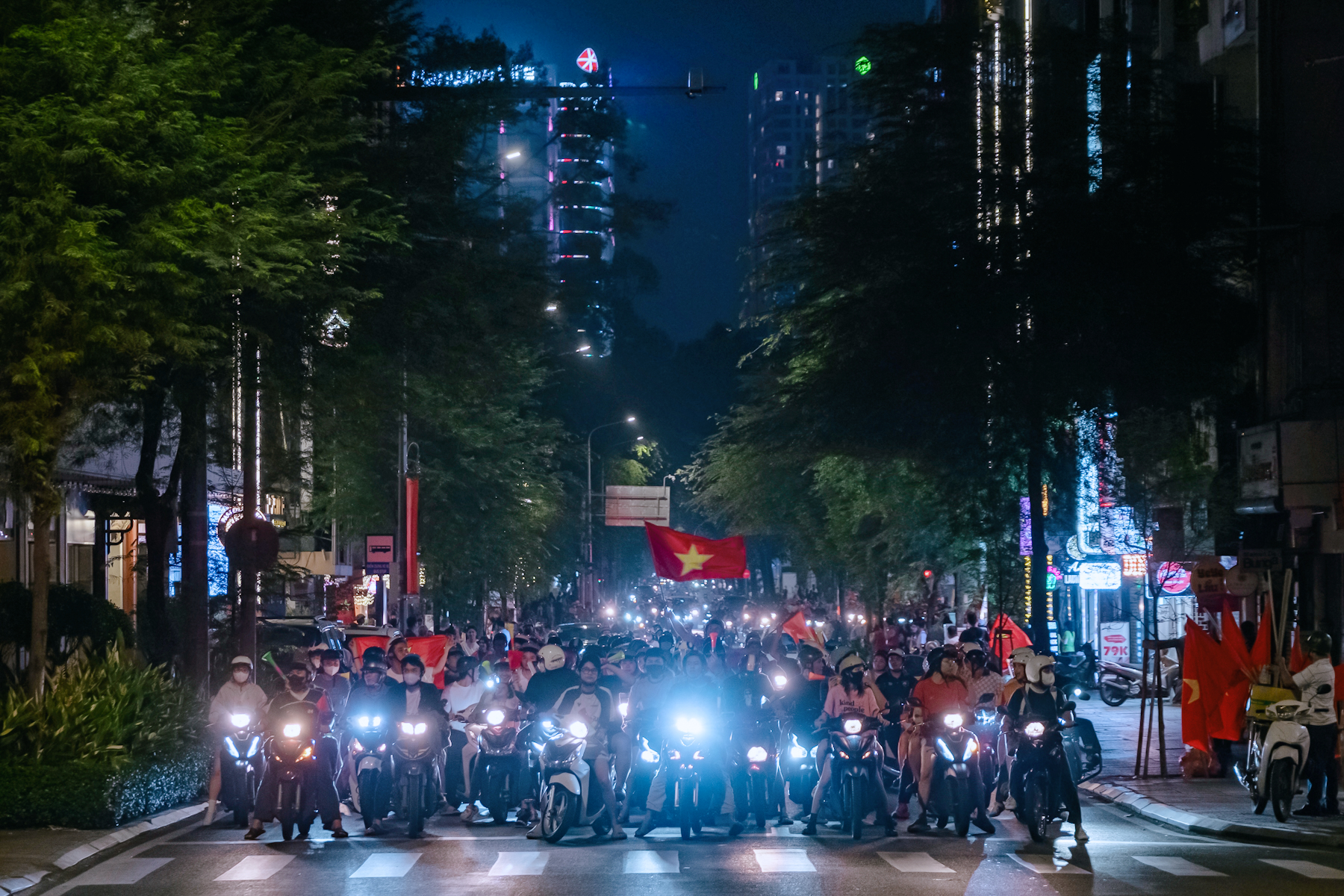 Dòng người đổ ra nhiều tuyến đường ở TP.HCM để ăn mừng. Tuy nhiên, tại nhiều ngã tư, người dân nghiêm túc chấp hành dừng chờ đèn đỏ.