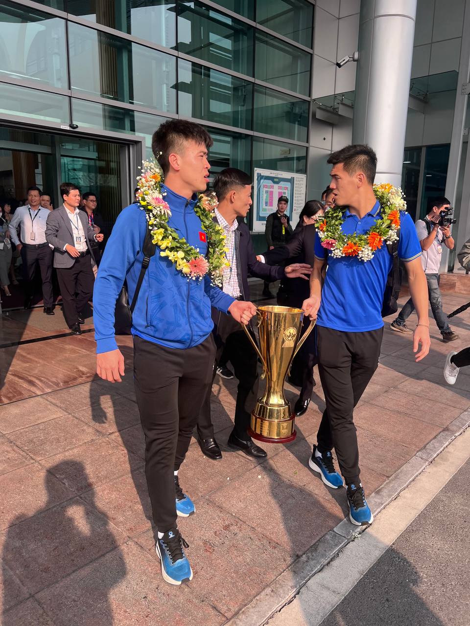 Ở sân bay, đội trưởng Duy Mạnh và đội phó Tiến Linh cùng nhau rước cúp