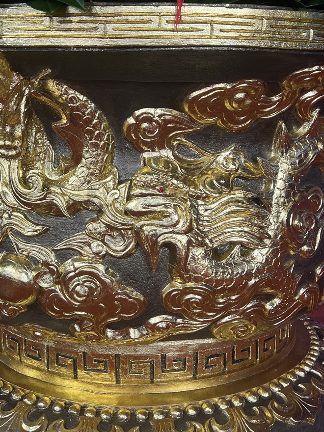 Trên thân chậu lan có hình tượng 9 con rồng được dát vàng 24K. Các mắt rồng được đính đá quý màu đỏ. Ngoài ra, trên đỉnh trán của từng con rồng còn được đính kim cương.