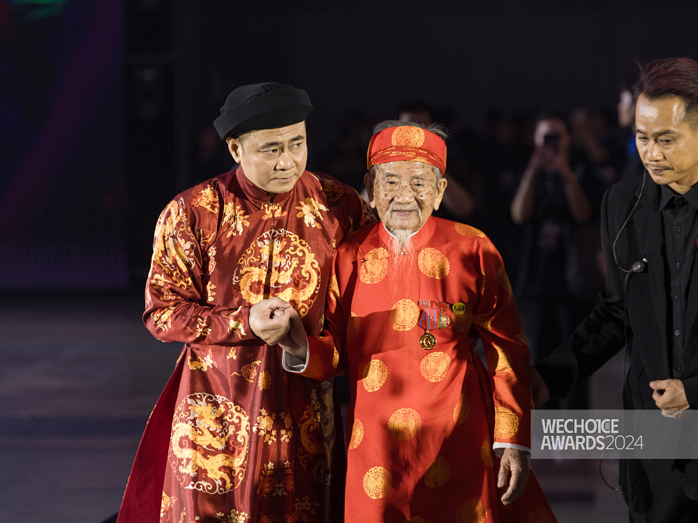 NSND Tự Long dìu nhà nghiên cứu Nguyễn Đình Tư lên sân khấu nhận giải.