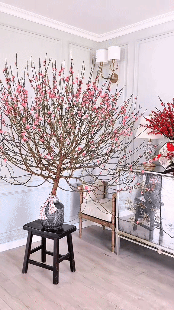 Bình hoa đào tuyệt đẹp của nhà Hannah Olala, đặt cạnh bàn hoa đỏ lại càng tô điểm vẻ đẹp
